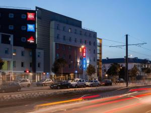 a city street with cars parked in front of a building at Ibis Budget Orly Chevilly Tram 7 in Chevilly-Larue
