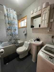 a bathroom with a toilet and a sink at Cabaña en Cochrane in Cochrane