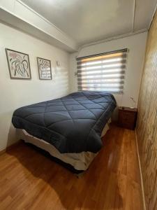a bedroom with a bed in a room with a window at Cabaña en Cochrane in Cochrane