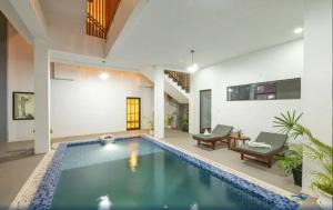 a swimming pool in a living room with a house at Punleu Raksmey Boutique in Phumi Ta Phul