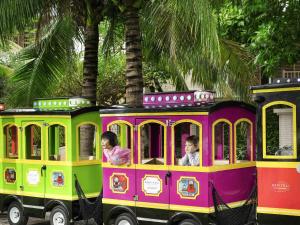 a colorful train with three people riding in it at Sofitel Sanya Leeman Resort in Sanya