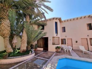 una villa con piscina e palme di Condominio 4 Estaciones a Paracas