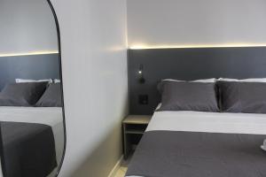 Un dormitorio con dos camas y un espejo. en Hotel Di Sica, en Balneário Camboriú