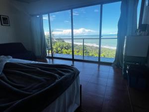 Un dormitorio con una cama y vista al mar. en Ranchos Remo Lodge, en Uvita