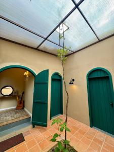 a building with green doors and a plant in a courtyard at Casa com Jacuzzi e Área Gourmet em Mury in Nova Friburgo