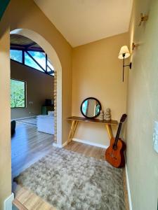 a room with a mirror and a guitar in it at Casa com Jacuzzi e Área Gourmet em Mury in Nova Friburgo