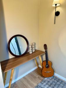 a mirror and a guitar on a wooden shelf at Casa com Jacuzzi e Área Gourmet em Mury in Nova Friburgo