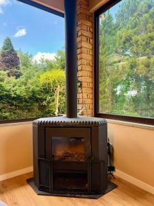 a fireplace in a room with a large window at Casa com Jacuzzi e Área Gourmet em Mury in Nova Friburgo