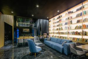 a library with a blue couch and bookshelves at Pytloun Grand Hotel Imperial in Liberec