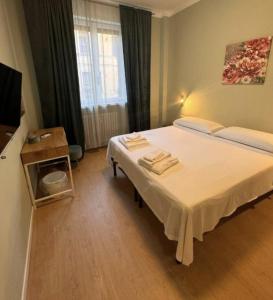 Un dormitorio con una cama y una mesa con toallas. en Suite excelsior garden living, en Parma