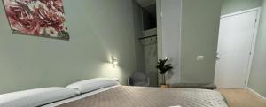 Un dormitorio con una cama blanca con una mesa. en Suite excelsior garden living, en Parma
