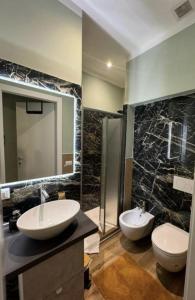 Un baño con dos lavabos, un inodoro y una ducha. en Suite excelsior garden living, en Parma