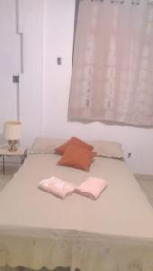 Una cama blanca con dos servilletas y dos almohadas encima. en Jomar family home, en Belém 9 fotos más