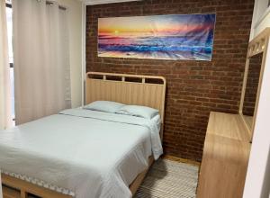 a bedroom with a bed and a brick wall at Weehawken Apartment NYC Skyline in Weehawken