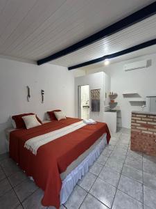 a bedroom with a large red bed in a room at Suítes Canoa Azul in Aracati