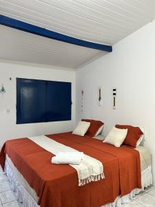 a bedroom with two beds with red and white sheets at Suítes Canoa Azul in Aracati