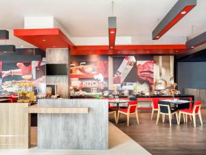 a kitchen with tables and chairs in a restaurant at Ibis Makassar City Center in Makassar +20 photos