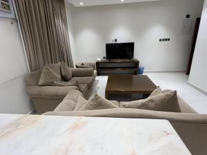 a living room with couches and a flat screen tv at شقق مفروشه رقميه في العزيزيه in Riyadh