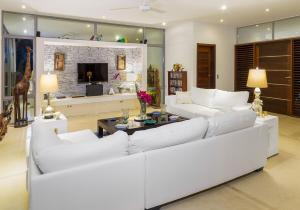 a living room with white couches and a tv at Luxurious beachfront house Las Brisa in El Limón