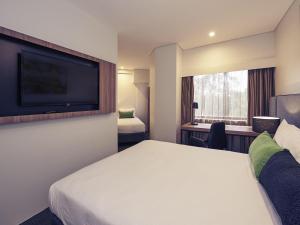 a hotel room with a bed and a flat screen tv at Mercure Penrith in Penrith +74 photos