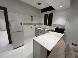 a kitchen with a white refrigerator and a counter at شقق مفروشه رقميه في العزيزيه in Riyadh +9 photos