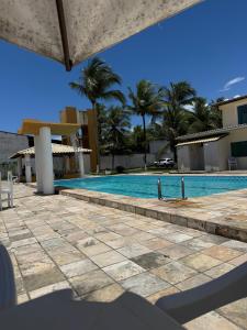 a swimming pool with palm trees in the background at Apto com piscinas e pé na areia in Valença