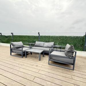 a patio with two couches and a table and chairs at Zimbali Ballito Vacation Apartment in Ballito