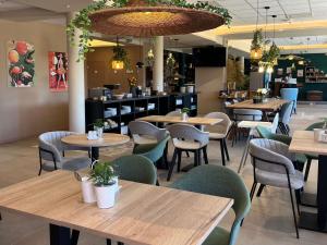 a restaurant with tables and chairs and a bar at Ibis Budget Porte de Camargue in Saint-Martin-de-Crau