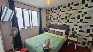 a bedroom with a bed and a window and a fan at Jorge Chavez Lima Airport Hostel - FREE AIRPORT PICK UP in Lima