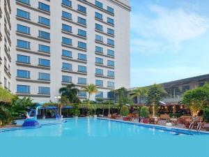 a large swimming pool in front of a hotel at Grand Mercure Medan Angkasa in Medan