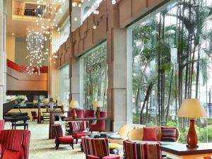 a lobby with chairs and tables in a building at Grand Mercure Medan Angkasa in Medan