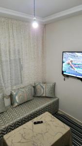 a living room with a couch and a flat screen tv at Bright Modern Apartment in Oualidia