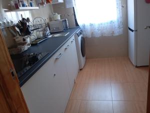 a kitchen with a sink and a white refrigerator at Calle lerida Apartamento céntrico in Jaén +3 photos