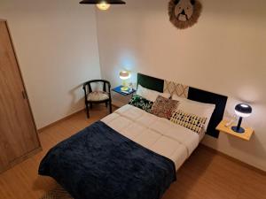 a bedroom with a large bed and a chair at Calle lerida Apartamento céntrico in Jaén
