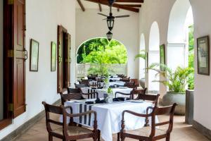 a dining room with white tables and chairs at Tamarind Hill Galle in Galle