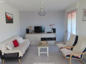 Una sala de estar con un sofá y sillas y un televisor. en Charmant Gîte 4* dans un Hameau Paisible des Vosges - FR-1-583-388, en Fougerolles