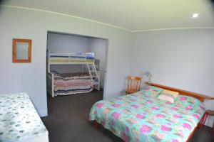 una camera con un letto e un letto a castello di Magical property close to Mangawhai a Mangawhai