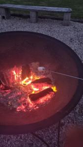 una griglia con hot dog e fuoco dentro di Magical property close to Mangawhai a Mangawhai