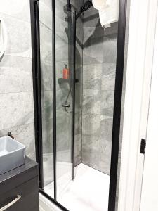 una ducha con puerta de cristal en un baño en The Aurora Apartments, en Peterborough