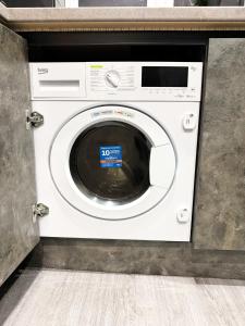 una lavadora blanca con un cartel en The Aurora Apartments, en Peterborough 6 fotos más