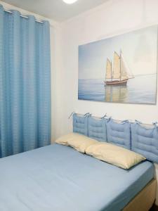 a bedroom with a bed with a painting of a sailboat at kit S1 condominio praia Bertioga - 600mt da praia in Bertioga