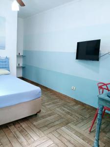 a bedroom with a bed and a tv on a wall at kit S1 condominio praia Bertioga - 600mt da praia in Bertioga +8 photos