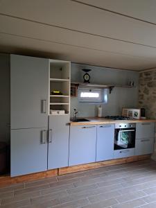 a kitchen with white cabinets and a stove at Gite Elin in Ronnet +9 photos