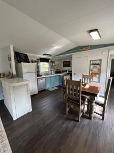 a kitchen with a table and chairs and a refrigerator at The Ozark Stargazer in Western Grove