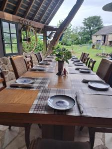 a long wooden table with chairs and plates on it at Gite Elin in Ronnet