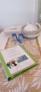 a book on a table with glasses and a bowl at Byron Bay Nest Homestay in Byron Bay