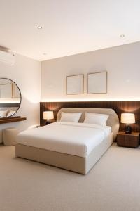 een slaapkamer met een groot wit bed met twee lampen bij luxury apartment AL Majdiah Residence K,Hittin,Boulevard, البوليفارد in Riyad +24 foto's