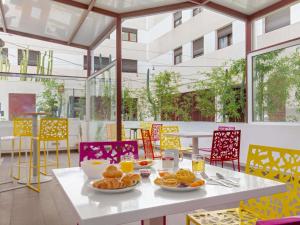 a table with plates of food on top of it at Novotel Suites Perpignan Centre - Grandes Suites & Confort Centre-Ville in Perpignan