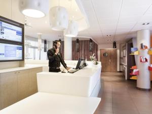 a man talking on a cell phone in an office at Novotel Suites Perpignan Centre - Grandes Suites & Confort Centre-Ville in Perpignan