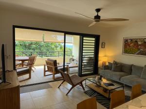 a living room with a couch and a table at Arbre a pain Beach Lodge in Punaauia